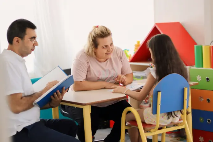 A group of people sitting around a table in a room